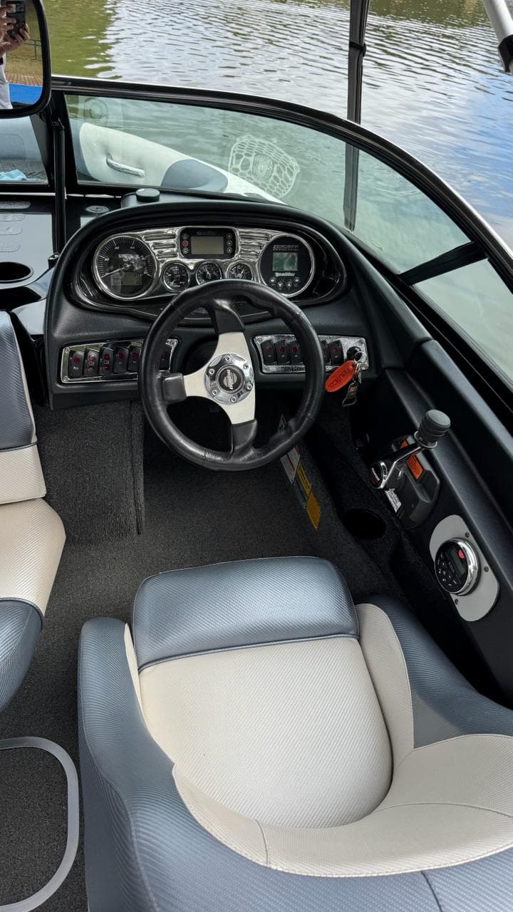 Painel e banco do piloto de um Malibu, com instrumentos e controle de velocidade